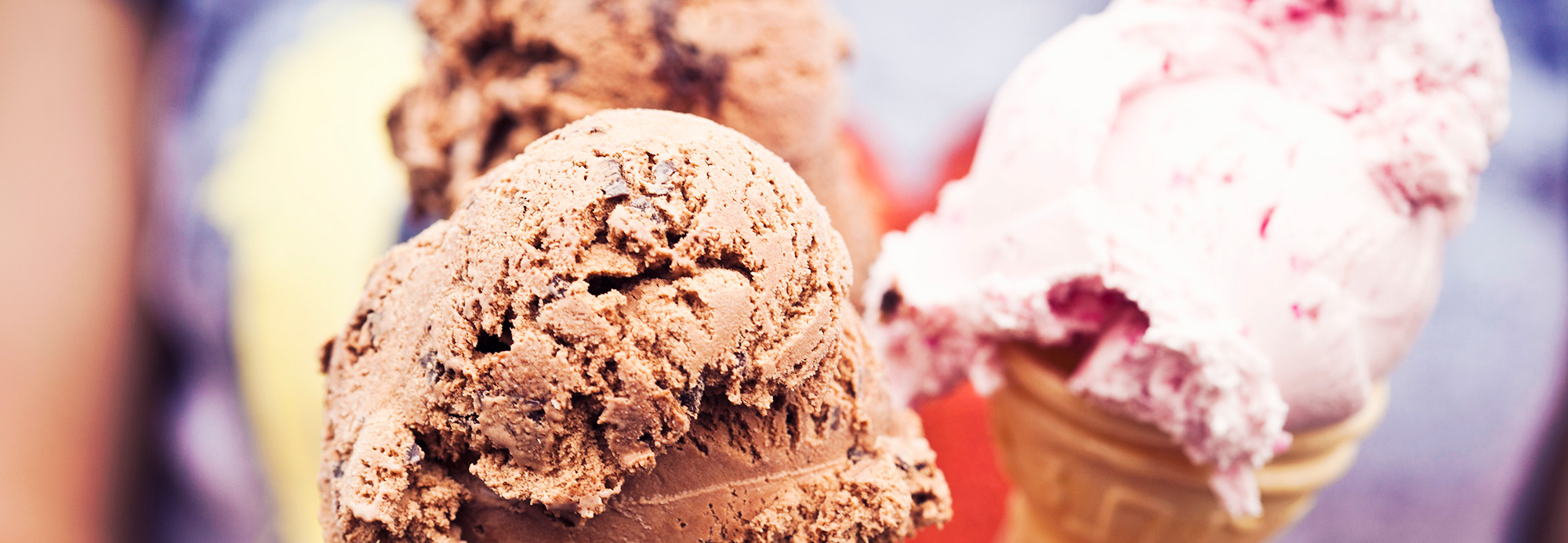 Three ice cream cones being held