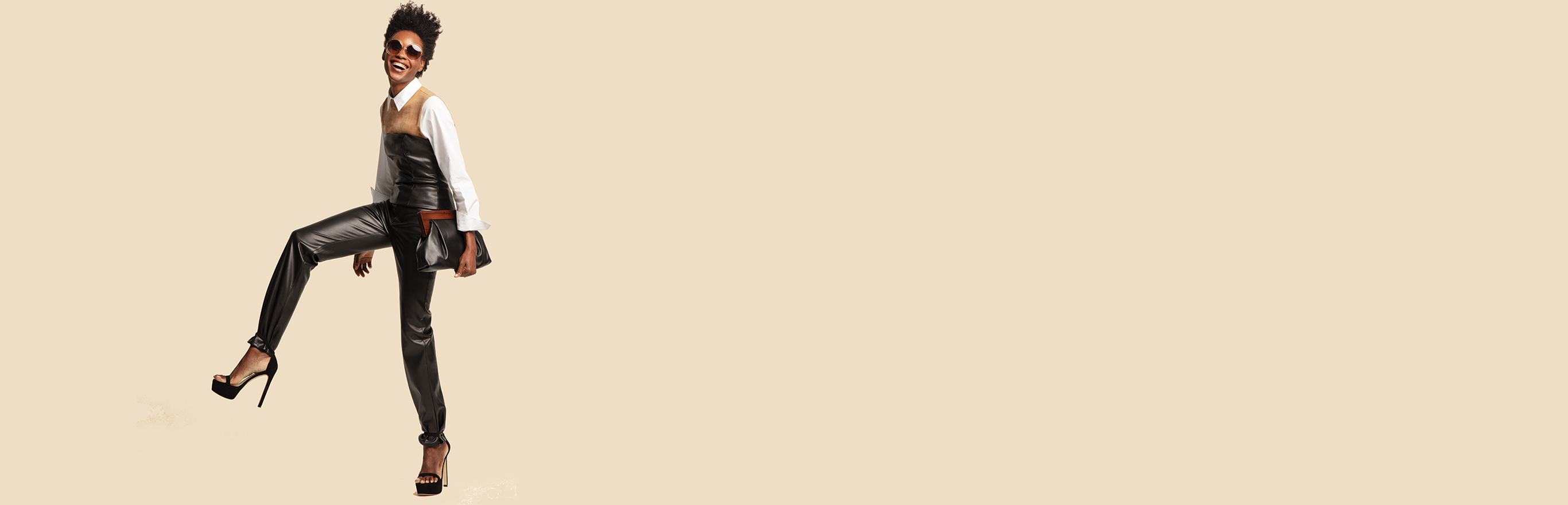 A woman wearing chic leather pants and carrying a clutch