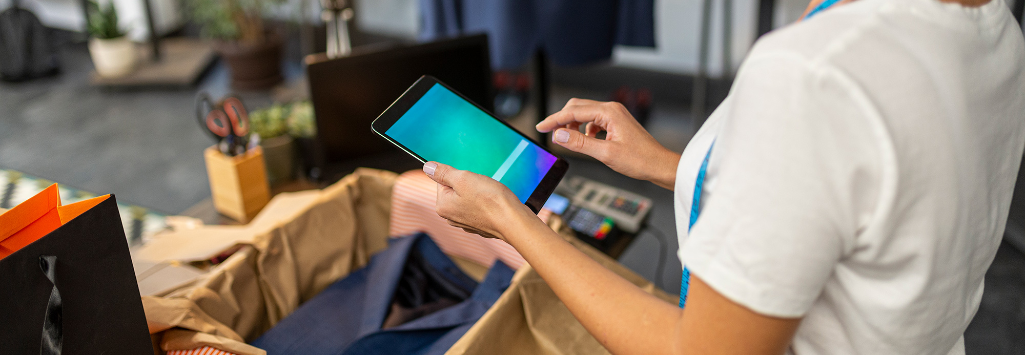 A clothing store employee using an electronic tablet
